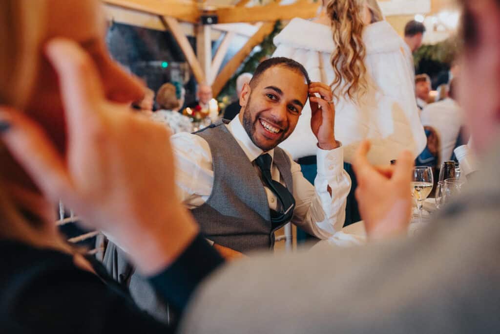 Candid wedding guest moment at Birtsmorton Court – a joyful smile captured during a lively reception at this stunning Cotswolds venue. The warmth and laughter of a winter wedding celebration shine through in this natural and emotive wedding photography.