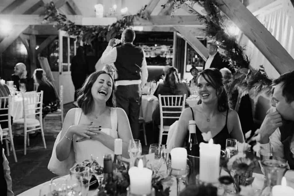 Heartfelt groom’s speech at Birtsmorton Court – the bride erupts in laughter, surrounded by loved ones in a beautifully decorated winter wedding reception. A candid black and white moment capturing the joy, emotion, and warmth of a stunning Cotswolds wedding celebration. Perfect inspiration for couples looking for documentary-style wedding photography.
