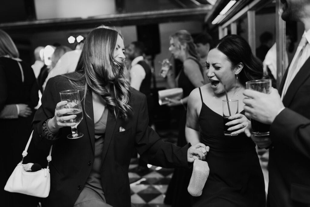 Joyful wedding guests dancing at the evening reception at Birtsmorton Court. A fun-filled moment with friends celebrating on the dance floor, capturing the energy and excitement of a winter wedding party in the Cotswolds.