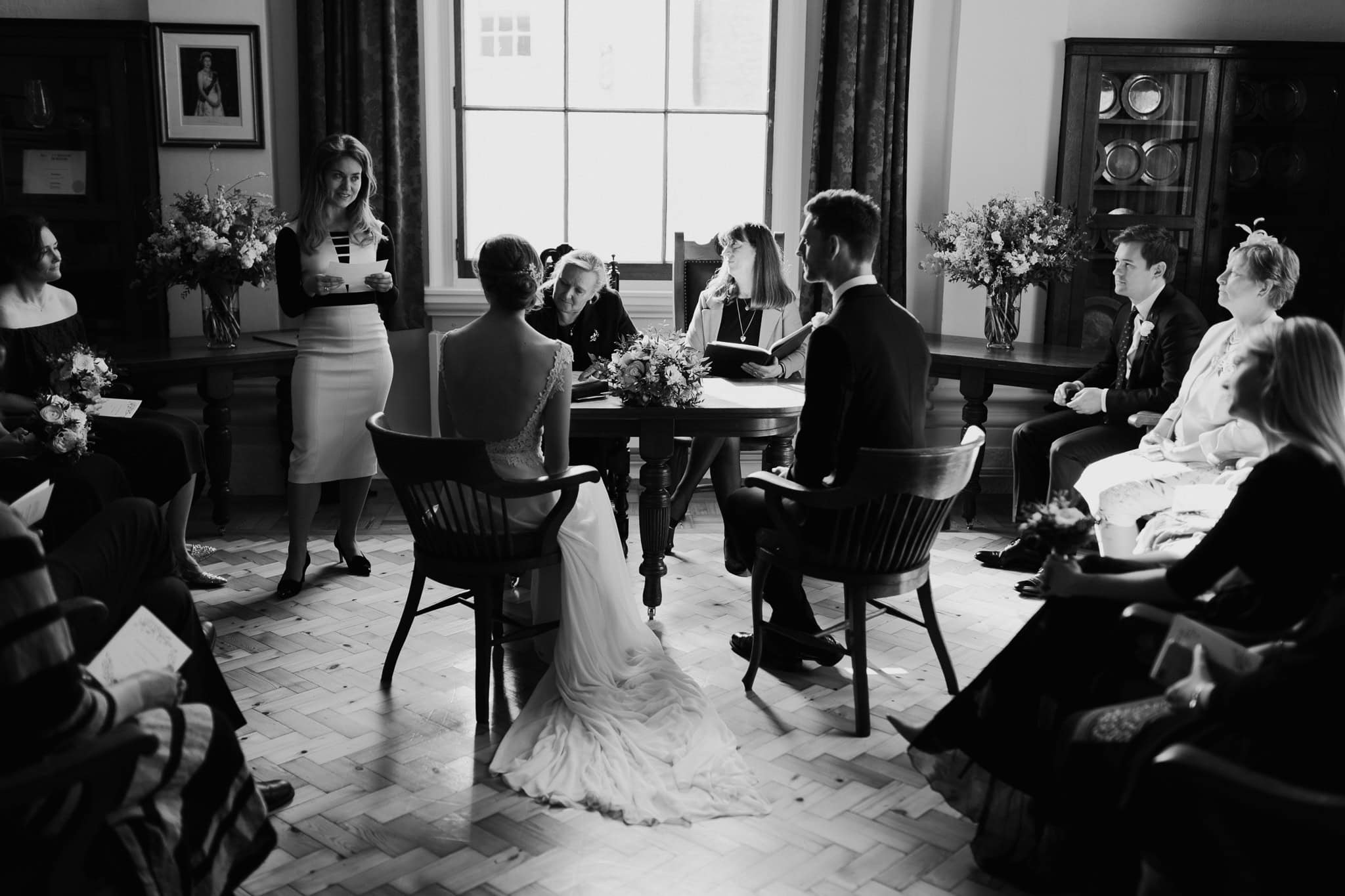 Bride and groom seated during their intimate Woodstock Town Hall wedding ceremony, surrounded by loved ones. A heartfelt black and white wedding moment captured beautifully.