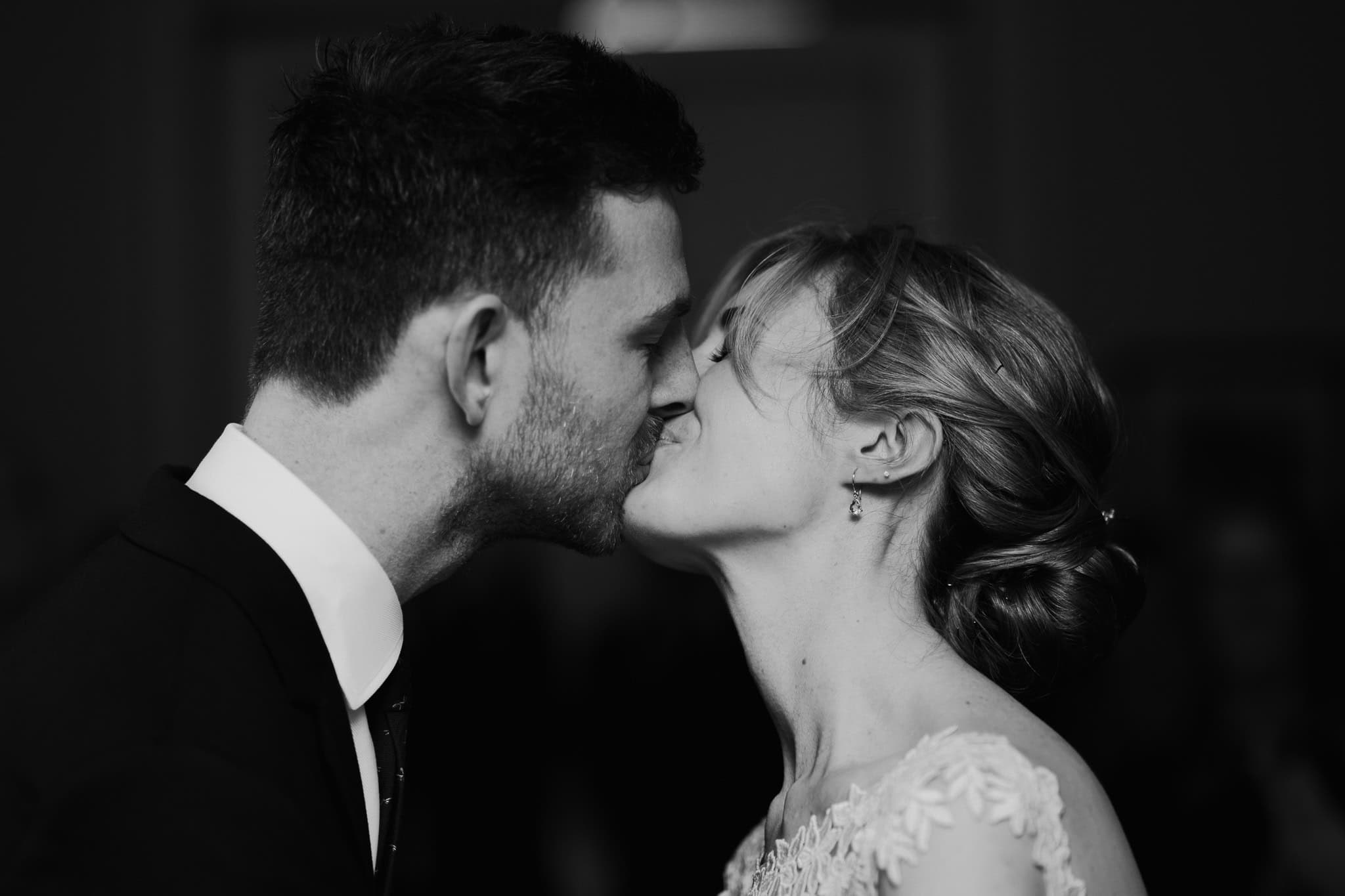 Black and white close-up of bride and groom sharing their first kiss as a married couple at Woodstock Town Hall. A timeless and emotional wedding moment beautifully captured.