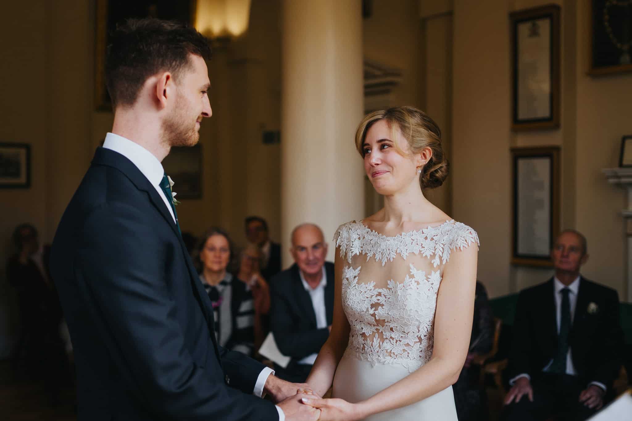 Bride and groom exchange heartfelt vows at Woodstock Town Hall, holding hands and sharing an emotional moment. A beautifully captured wedding ceremony filled with love and joy.