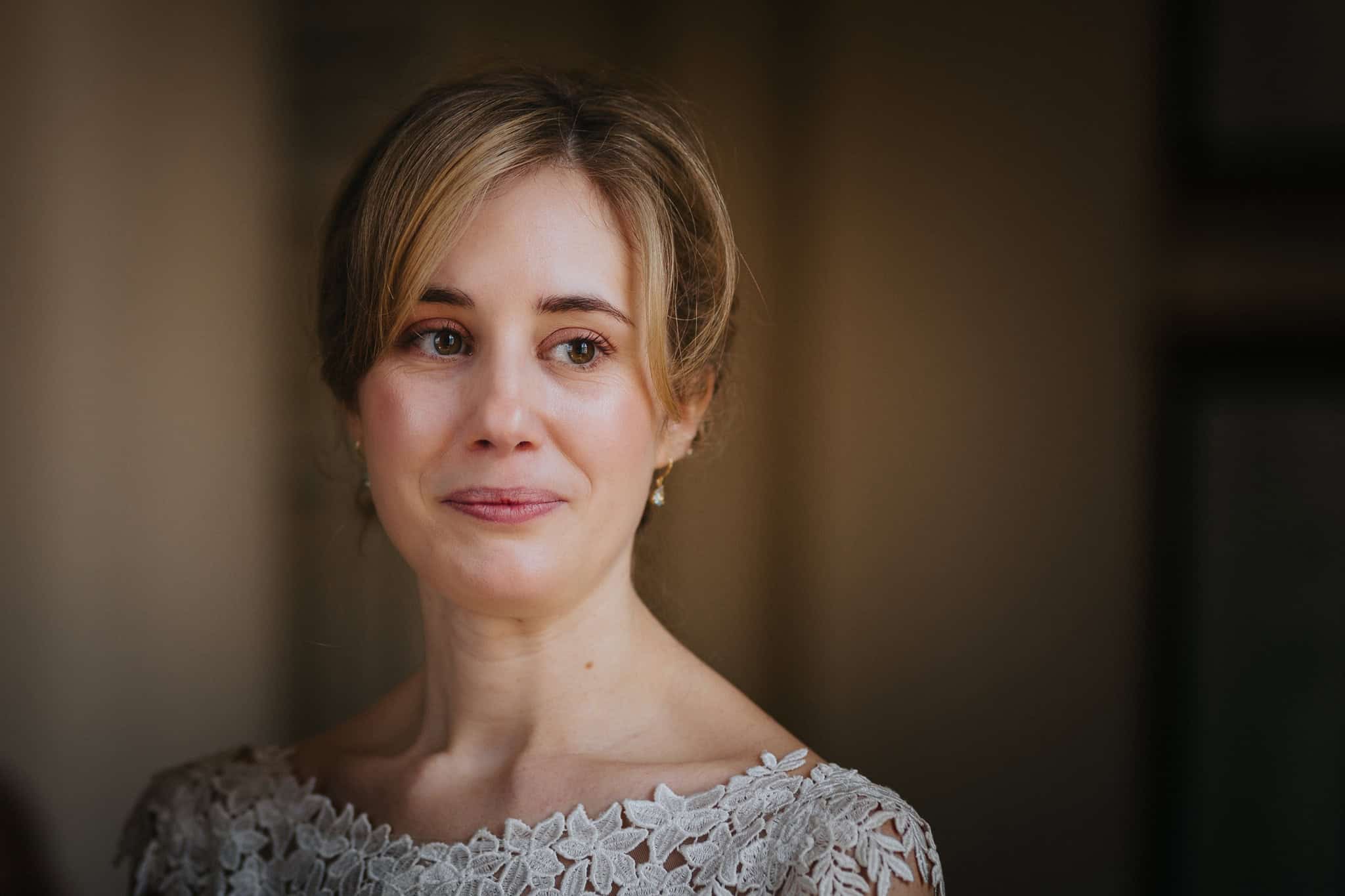 A close-up portrait of the bride with teary eyes and a soft smile during her wedding ceremony at Woodstock Town Hall. A beautifully captured emotional and intimate wedding moment.