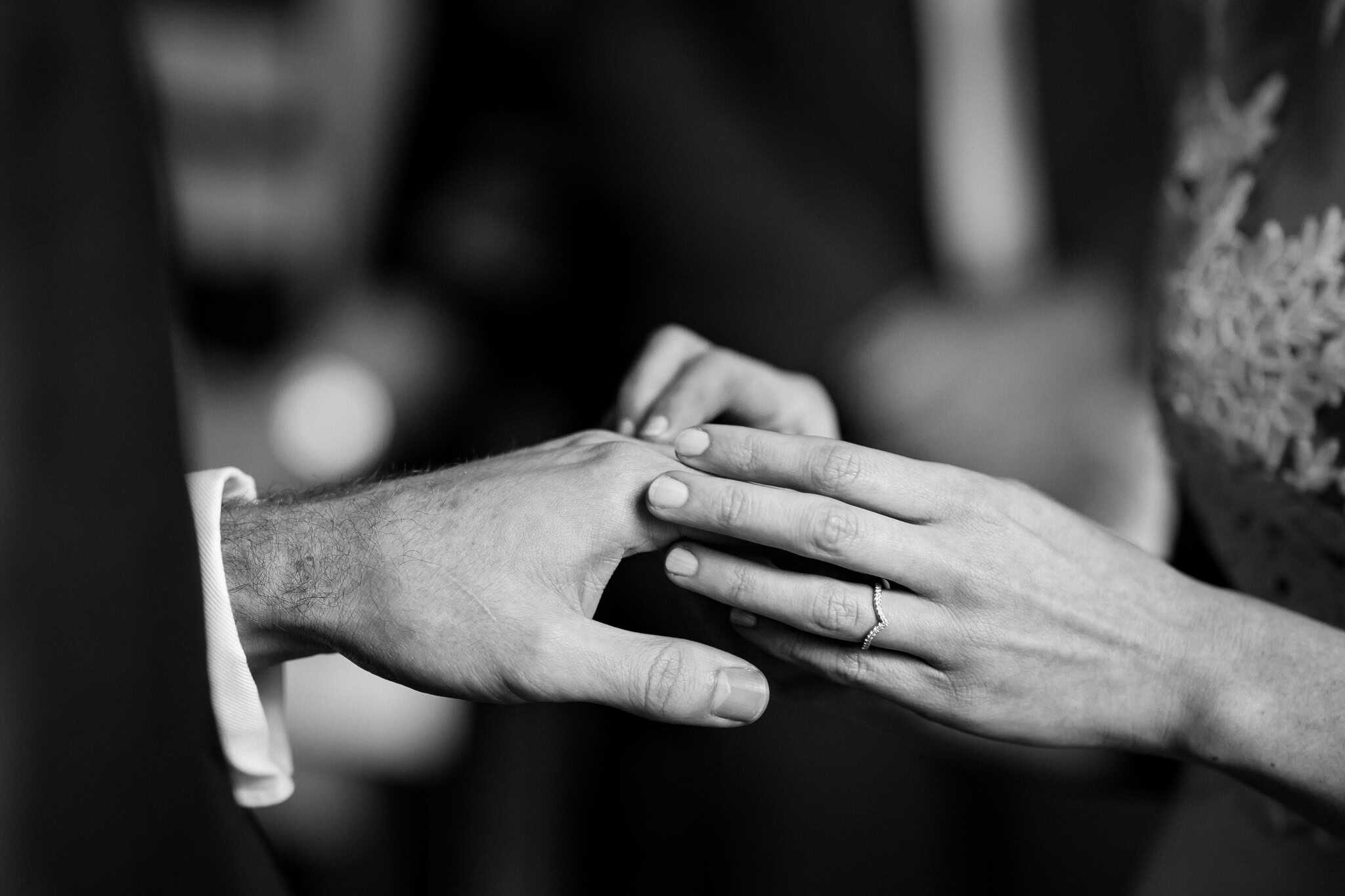 Black and white close-up of the bride gently placing the wedding ring on the groom’s finger during their ceremony at Woodstock Town Hall. A timeless and emotional wedding moment captured beautifully.