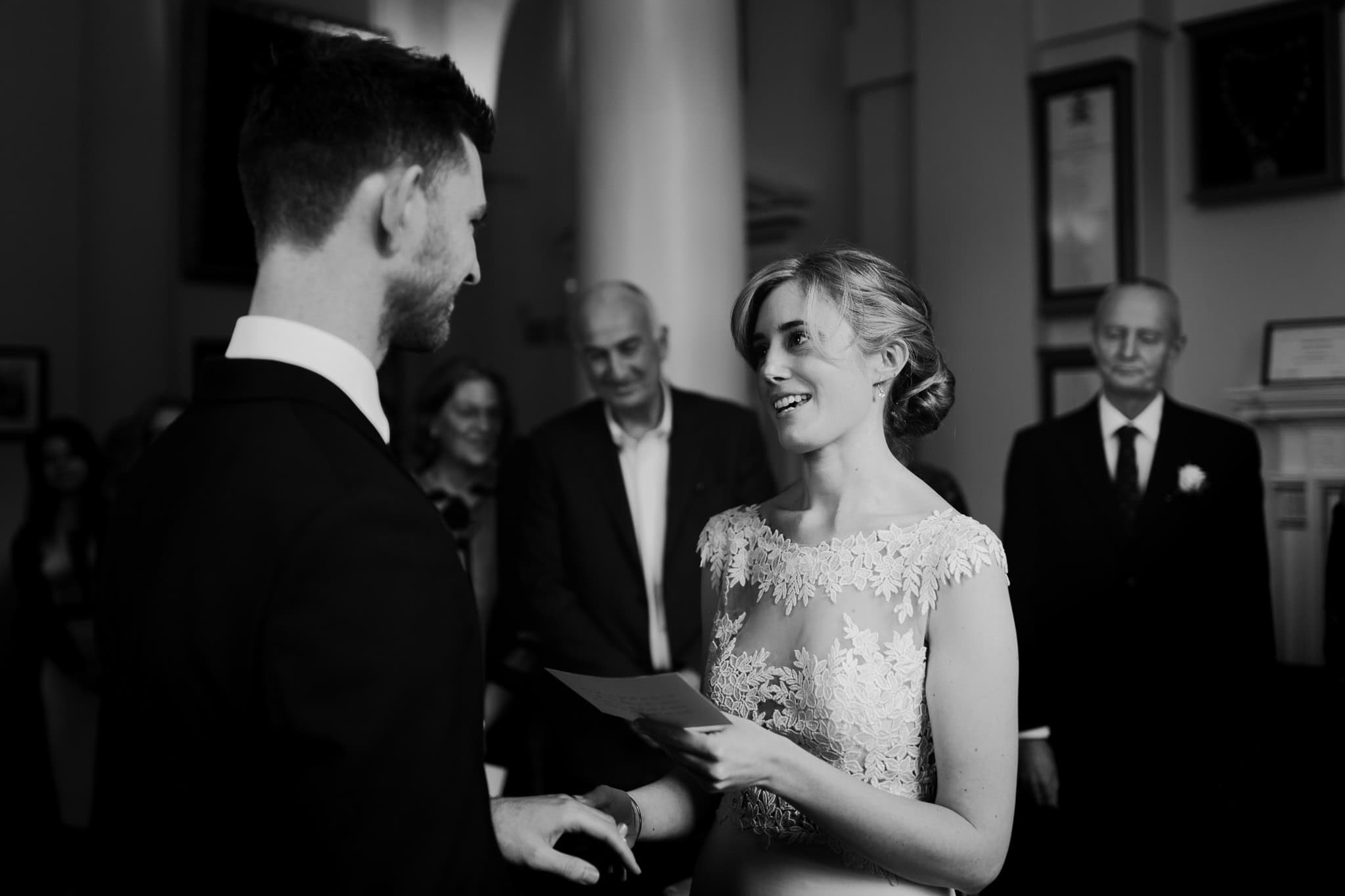 A heartfelt black and white moment as the bride reads her vows to the groom during their wedding ceremony at Woodstock Town Hall. A beautifully captured emotional exchange of love.