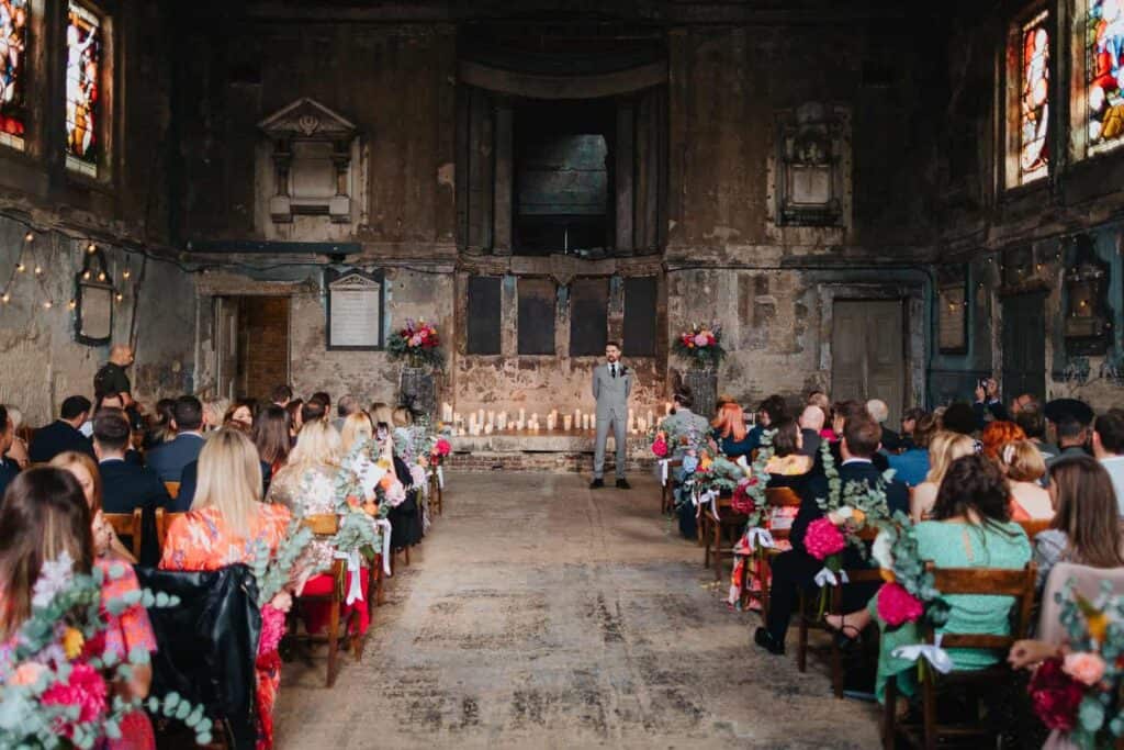 pan młody stojący przy ołtarzu podczas ceremonii ślubnej w industrialnej kaplicy