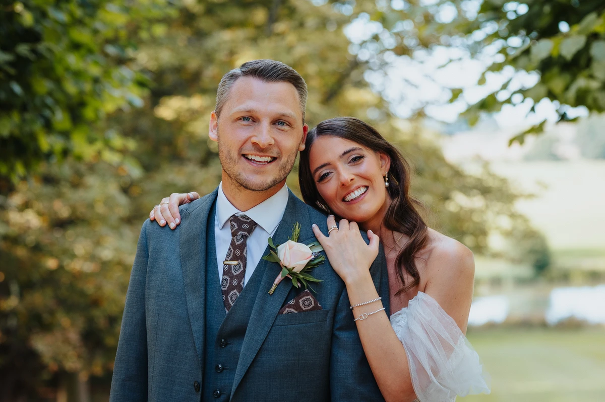 Natural wedding portrait of bride and groom standing together under the trees in Buckinghamshire countryside