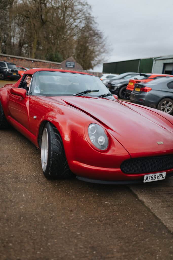 Father of the bride arriving at Thorpe Garden wedding venue in a red TVR sports car for a winter wedding in Staffordshire.